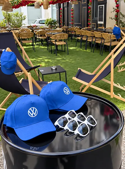 Capsules Volkswagen bleues et lunettes sur table ronde en extérieur