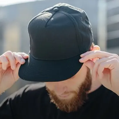 Homme ajustant une casquette noire personnalisable