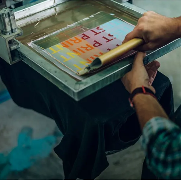 Personne imprime un t-shirt personnalisé avec une machine sérigraphie professionnelle