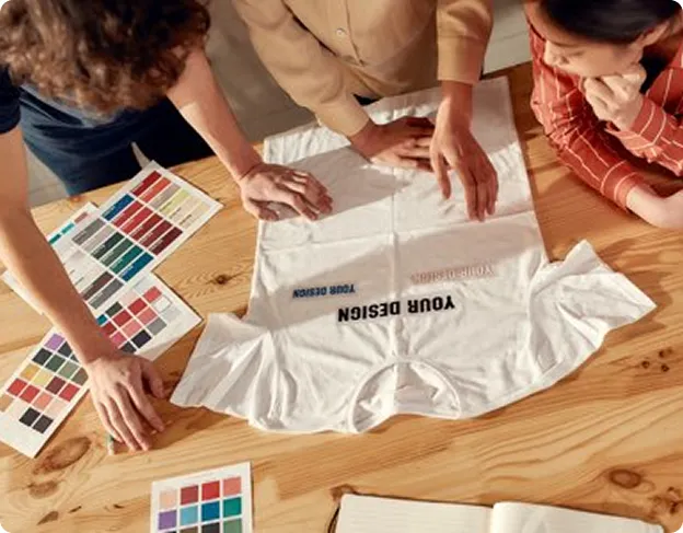 Trois personnes personnalisent un t-shirt avec des couleurs et un design créatif